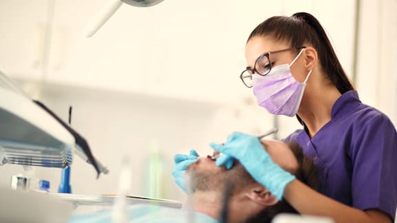 Female dentist performing service on patient
