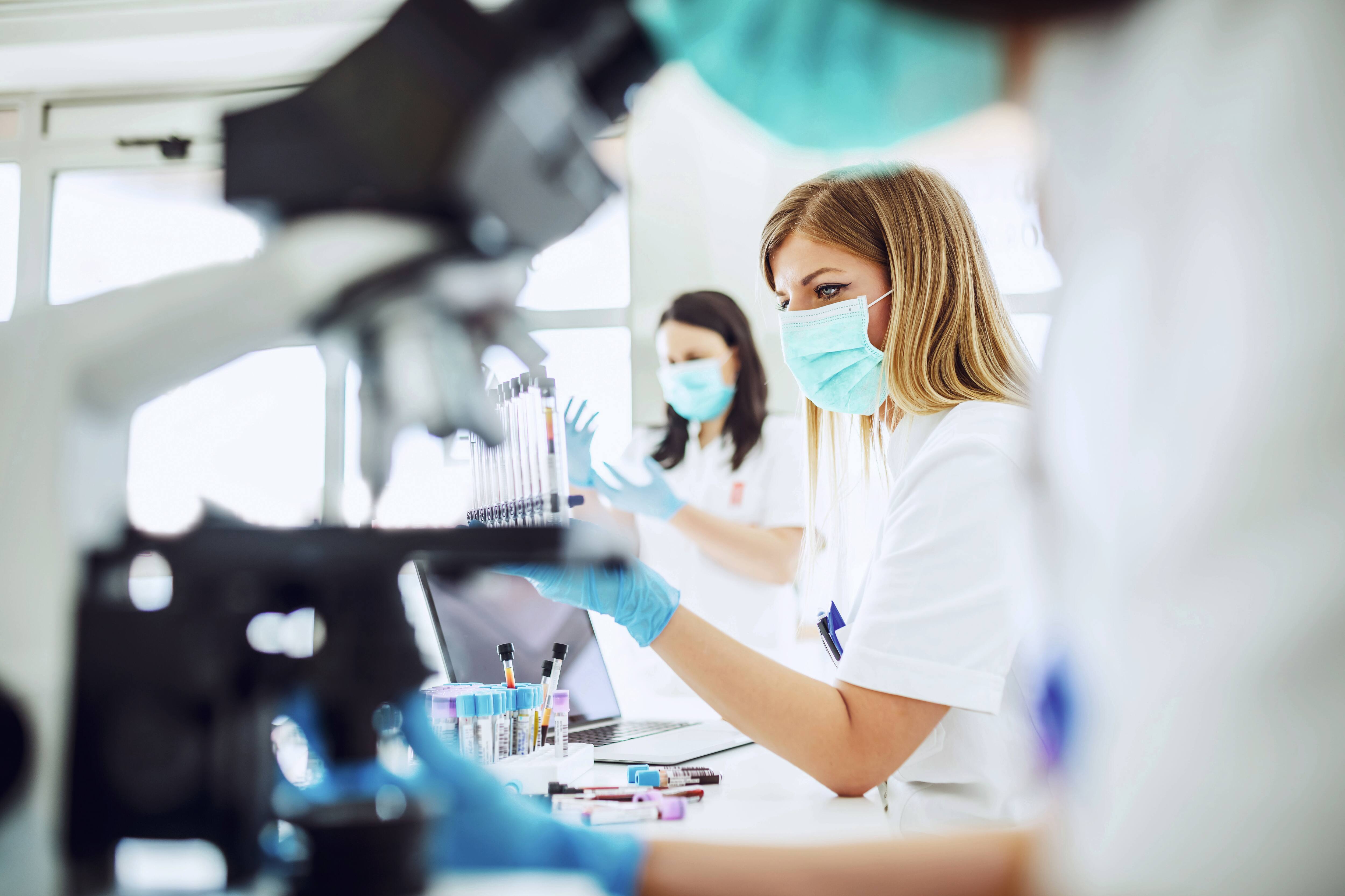 Female scientists working at microscope in laboratory