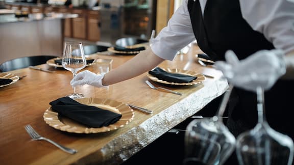 Waiter setting the table for meal at restaurant