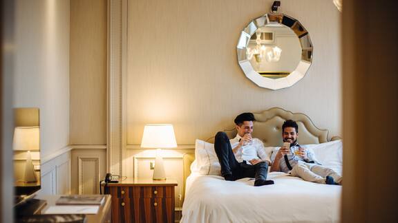 Una coppia di ragazzi siede sul letto di una stanza d'albergo