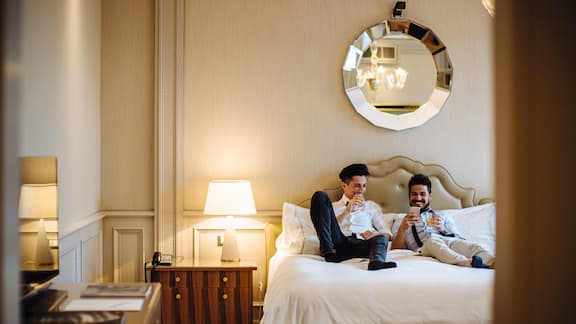 Una coppia di ragazzi siede sul letto di una stanza d'albergo