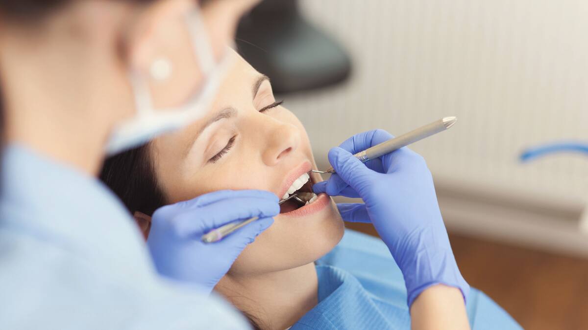 Egy női pácienst kezelnek a fogorvosnál.
