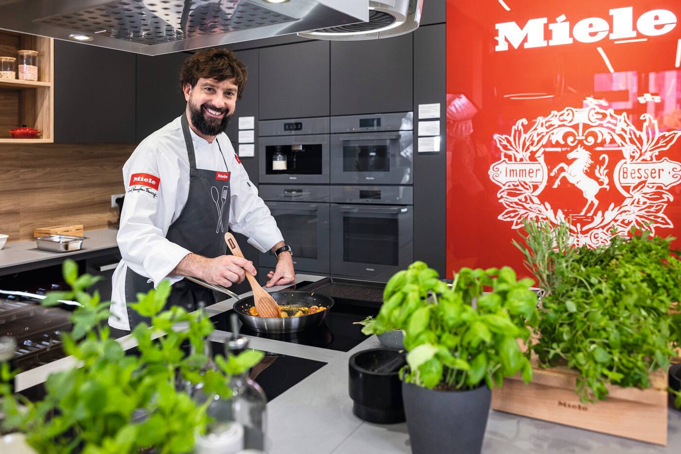 Zdjęcie portretowe szefa kuchni Przemysława Błaszczyka gotującego w kuchni w salonie Miele Zdjęcie portretowe szefa kuchni Przemysława Błaszczyka gotującego w kuchni w salonie Miele