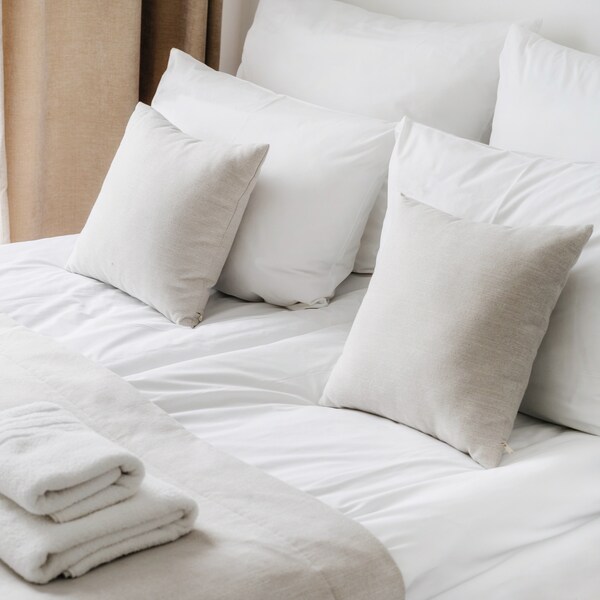 Bett mit weißer Bettwäsche