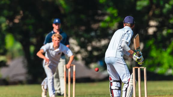Young people play cricket