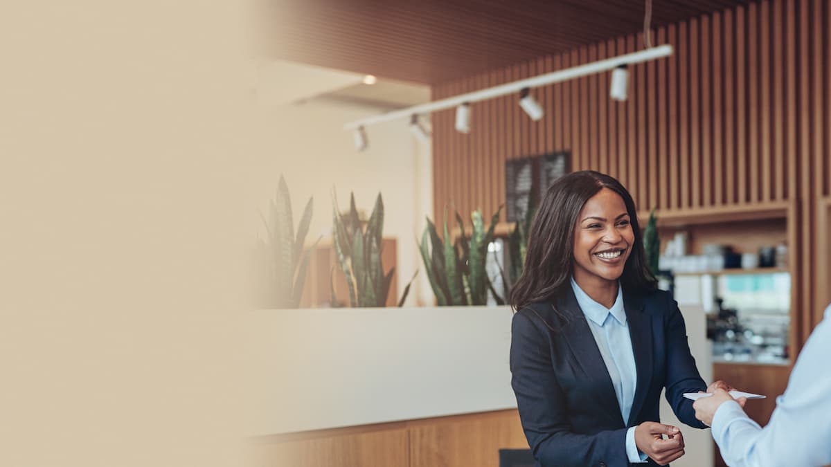 Business conversation in a hotel lobby including a female receptionist, a business man and woman