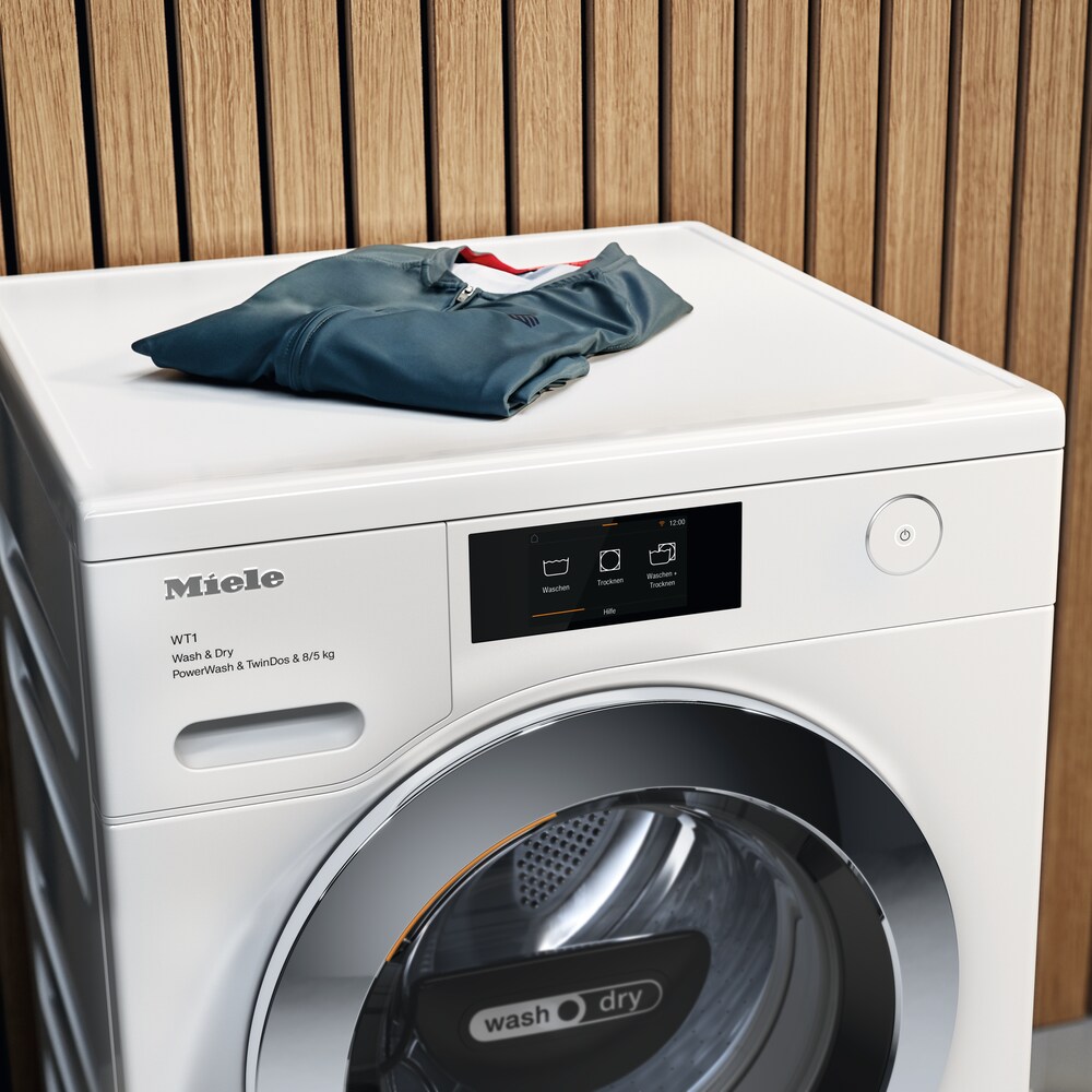 Mamă servindu-și fiica cu mâncare într-o bucătărie Miele