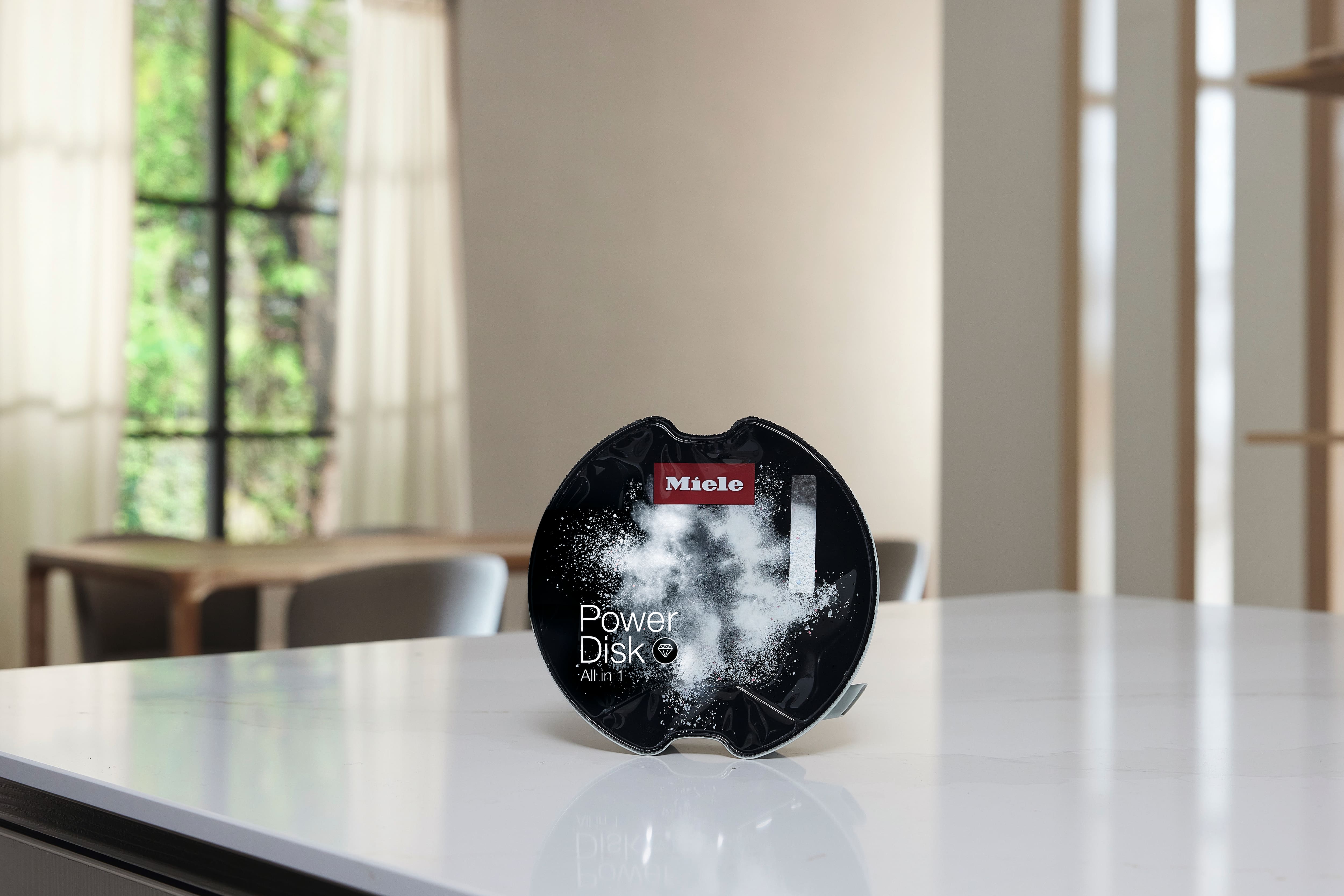Detergent do zmywania naczyń w zmywarce Miele PowerDisk na blacie kuchennym