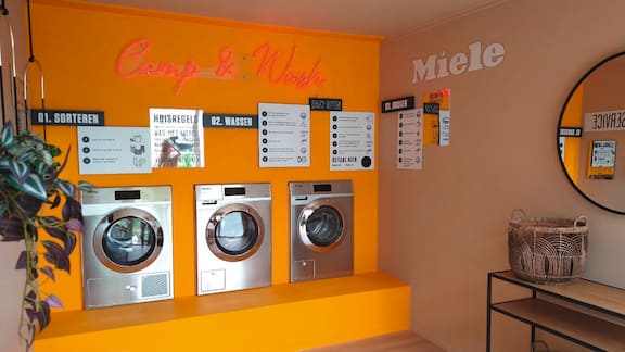 Hånd sætter telt op på campingplads.