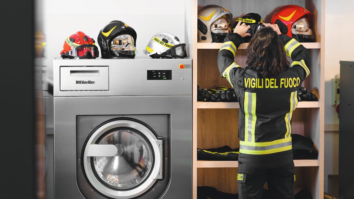 Un vigile del fuoco posiziona un casco in seguito al lavaggio