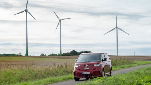 Roter Servicebulli fährt auf einer Landstraße