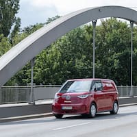 Der rote Miele Service VW IDBuzz fährt über eine Brücke