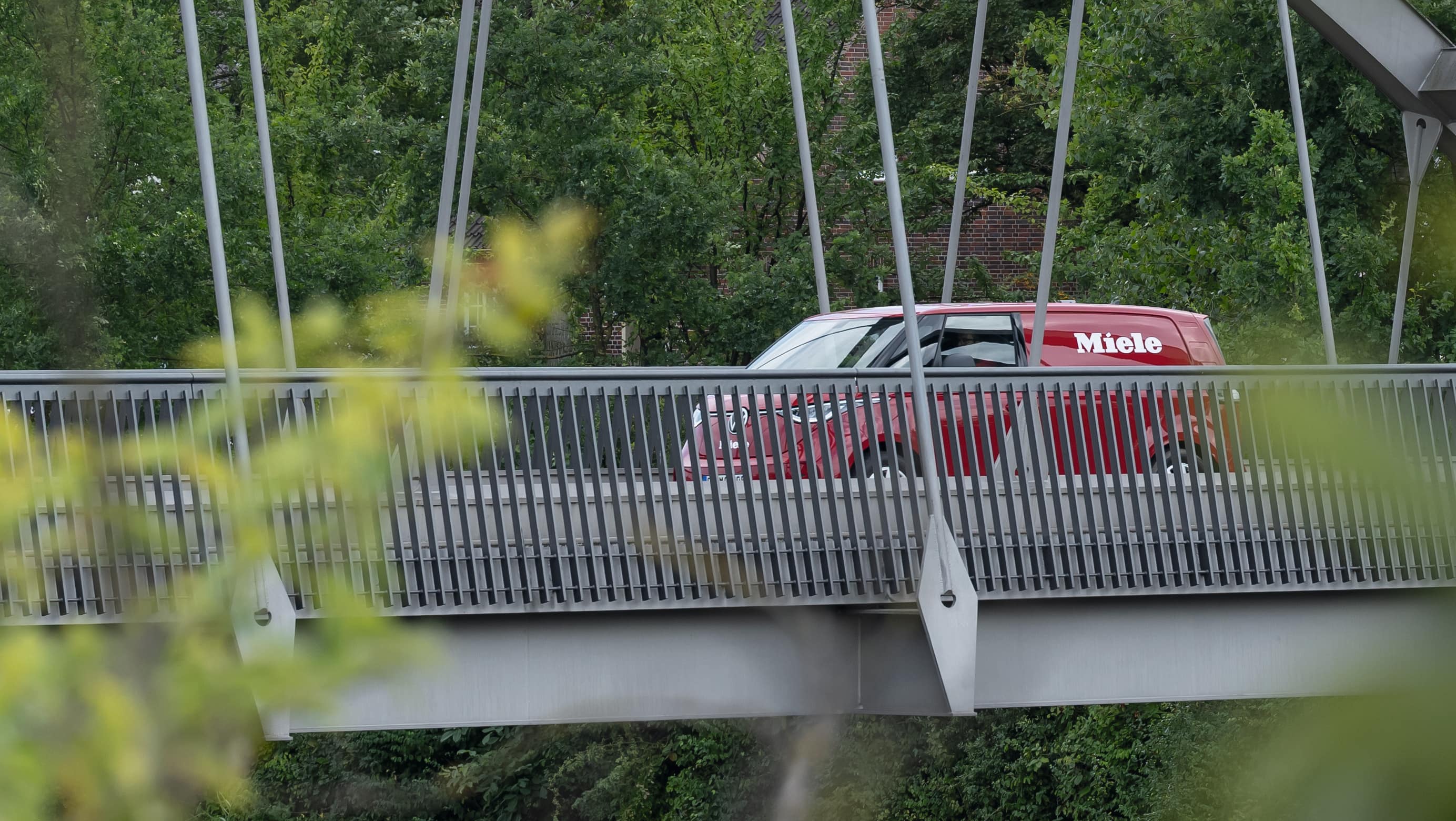 A red Miele service van drives across a bridge on its way to its next service call out job.