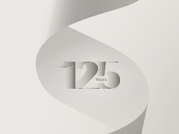 O logótipo do aniversário dos 125 anos da Miele sobre um fundo cinzento.