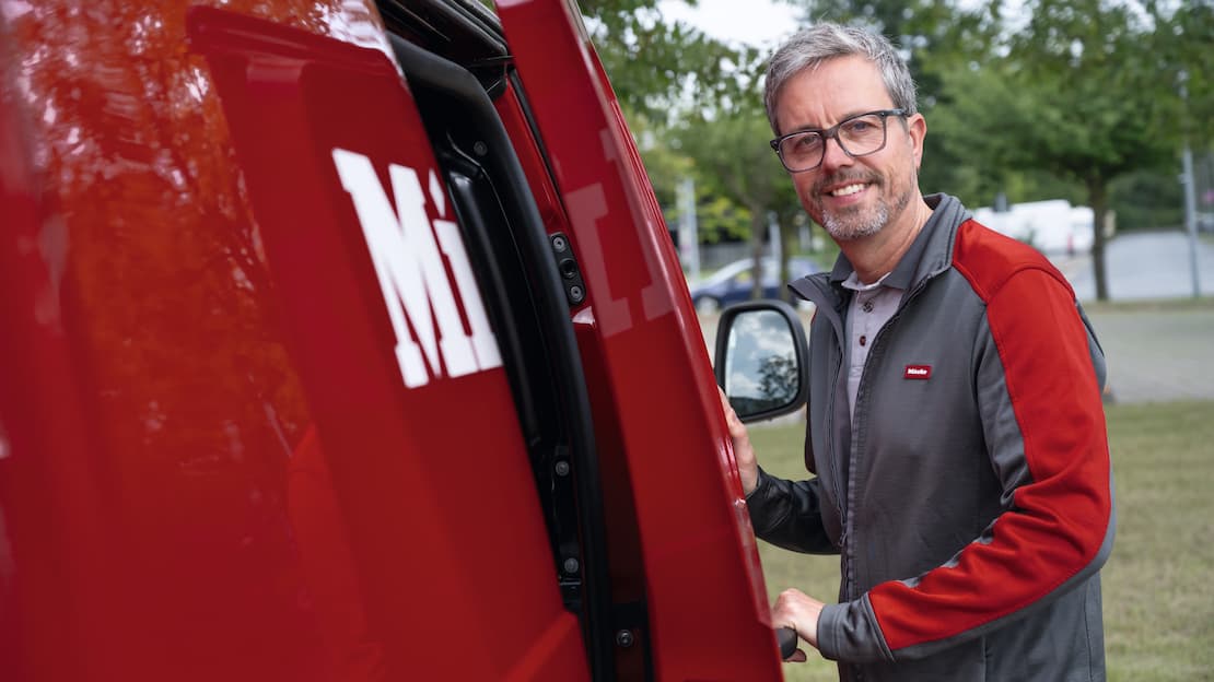 Service technician opens sliding door of Miele Professional service van.