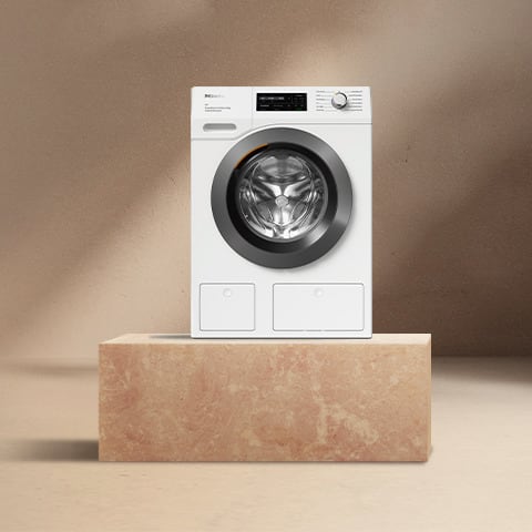 A Miele washing machine on a pedestal A Miele washing machine on a pedestal