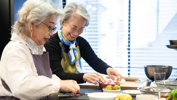 Zwei ältere Frauen kochen gemeinsam in einem Pflegeheim  