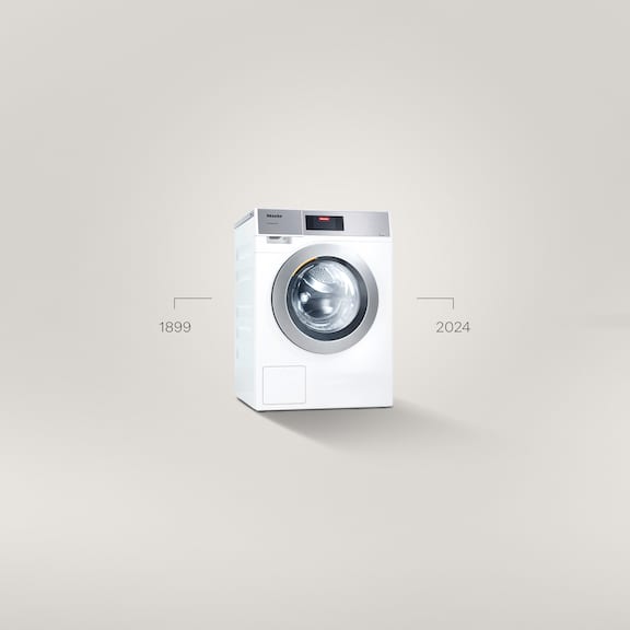 A Little Giant Performance Plus washing machine stands in front of a grey background