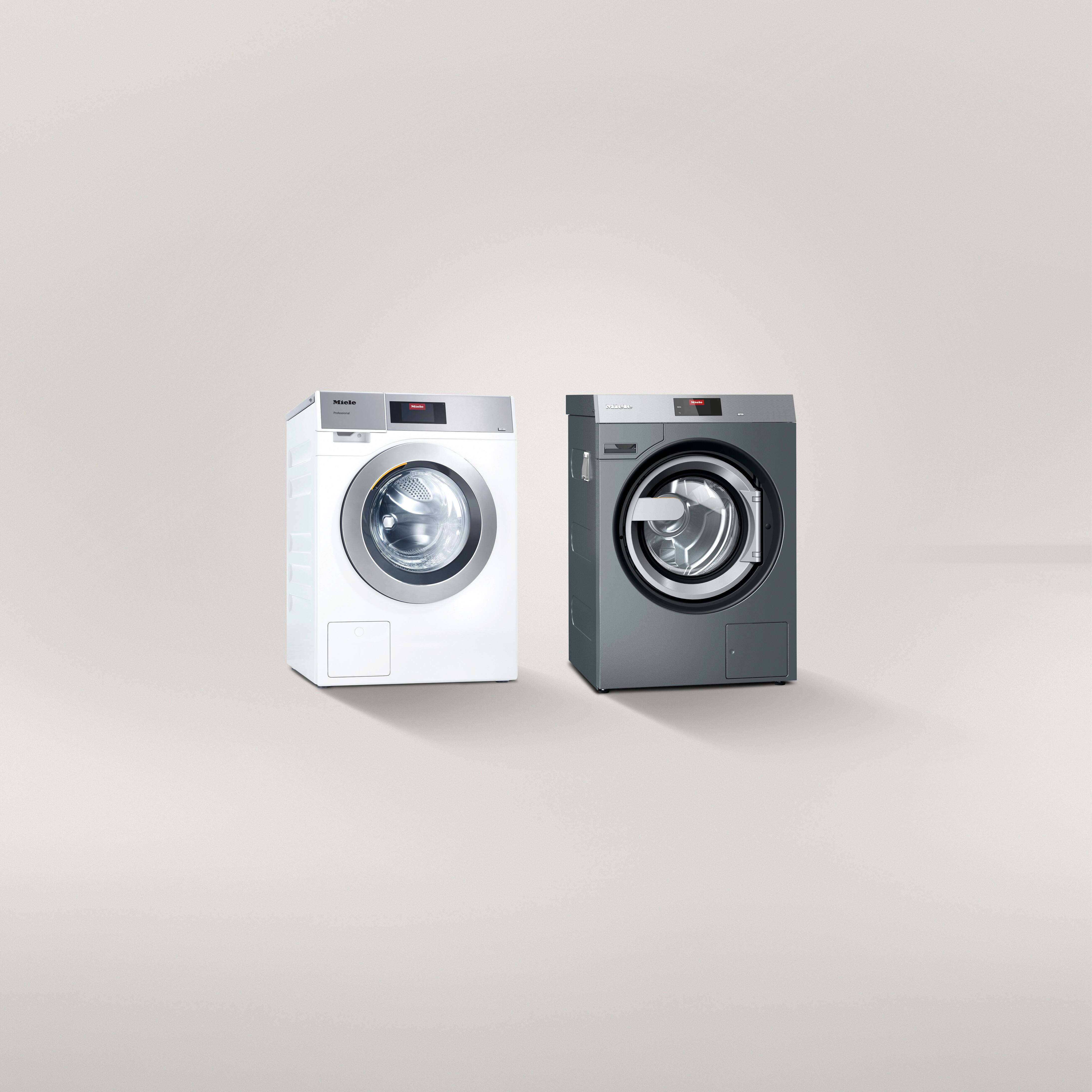 Zwei Waschmaschinen nebeneinander auf graumen Architekturfond