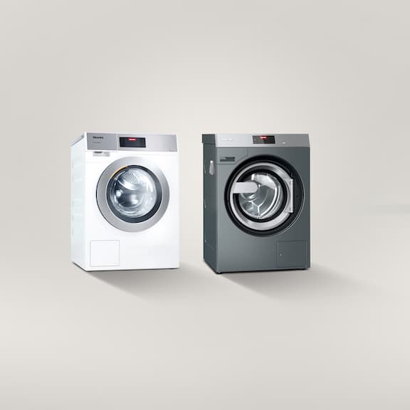 Two washing machines next to each other on a grey background