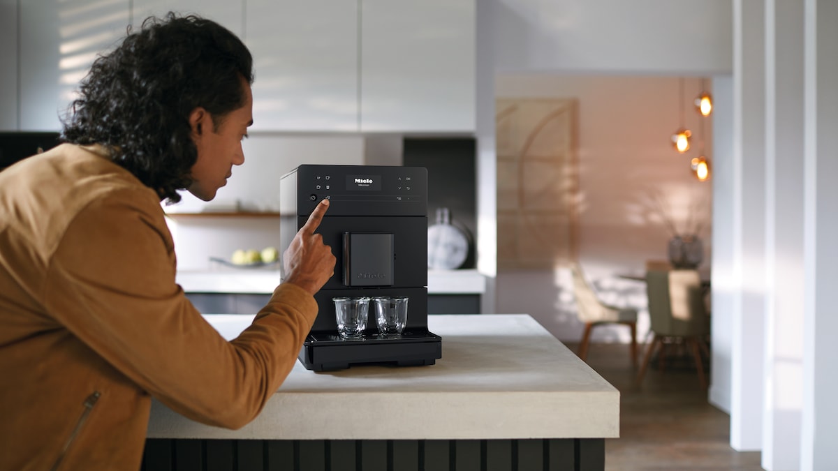 woman turning on a Miele coffee machine