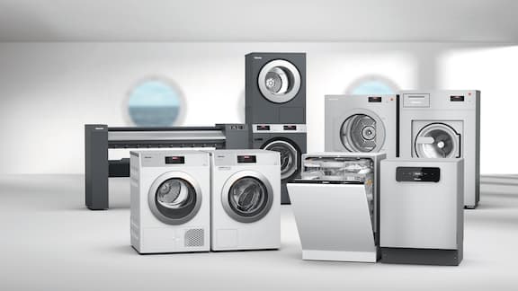 Washing machines, tumble dryers and an ironer on a grey background with a porthole