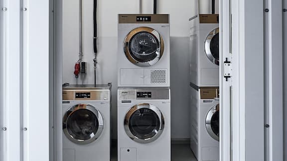 Ein Blick in die Waschküche de Collegium Academicums. Waschmaschinen und Trockner der Serie Kleine Riesen, PWM 906 und PDR 908 HP sind zu sehen. 