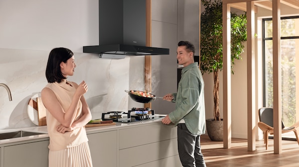 mann and woman cooking and talking in their kitchen