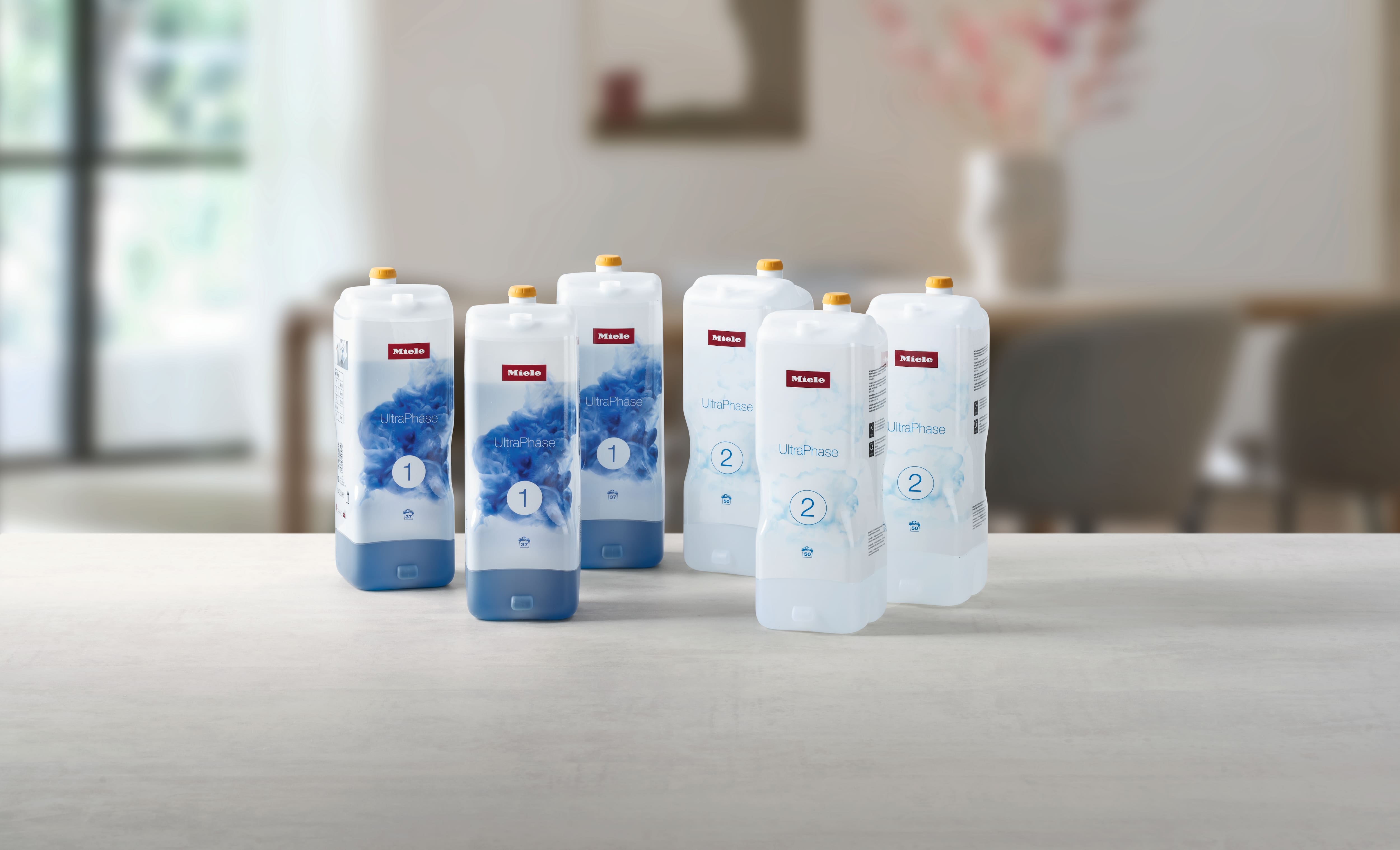 6 butelek detergentów do prania Miele UltraPhase na blacie w nowoczesnym wnętrzu 6 butelek detergentów do prania Miele UltraPhase na blacie w nowoczesnym wnętrzu