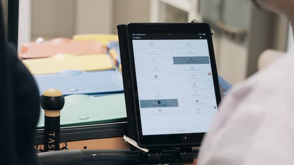 Reinigungskraft arbeitet mit einem Tool auf dem Tablet ihres Reiningungswagens
