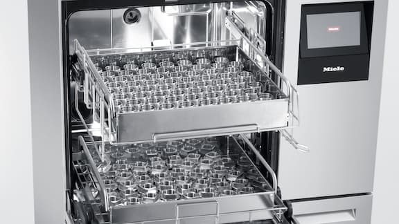 Vista detallada del equipo de limpieza ExpertLine PLW 8636 para la limpieza de piezas industriales, equipado con diversos componentes metálicos torneados