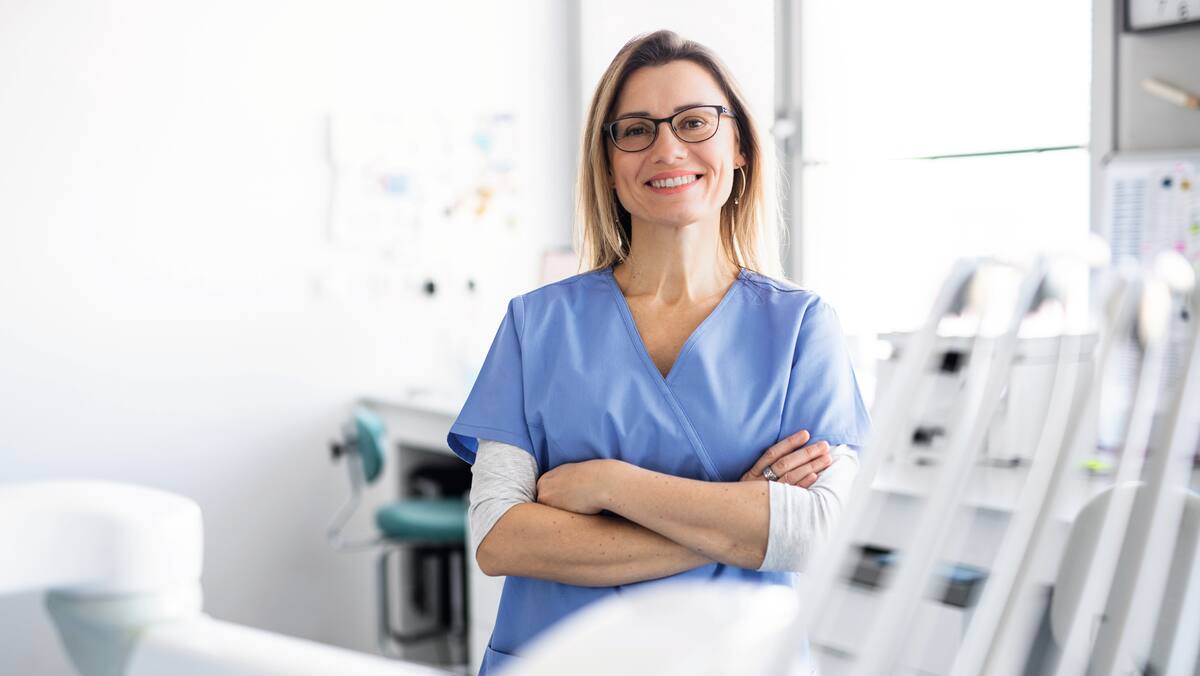 Zubař s instrumentáriem vyšetřuje zuby pacientky.