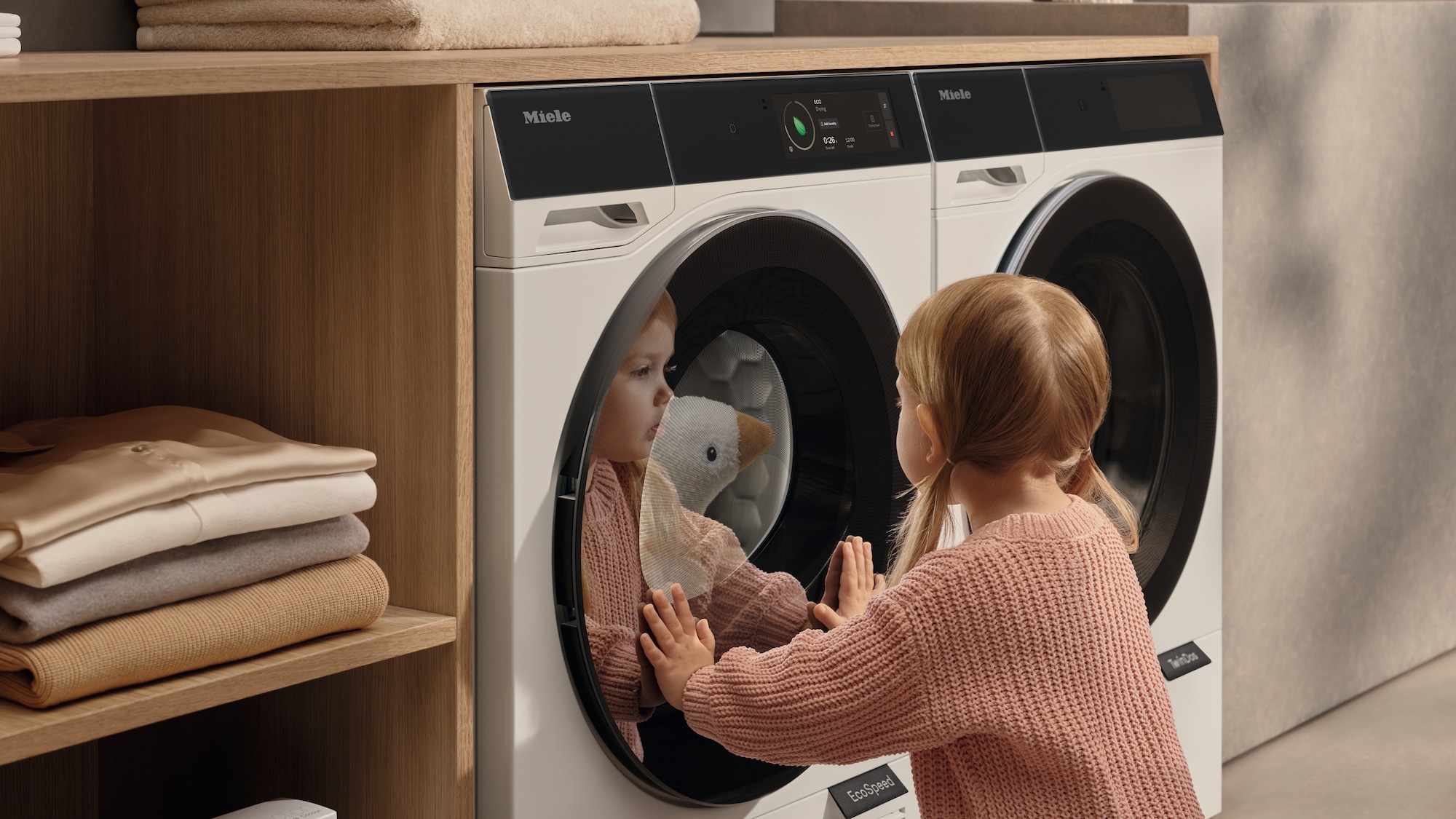 laundry room with hanged shirts and Miele washing machine