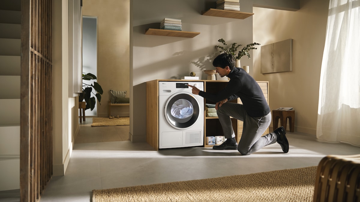 man turning on Miele washerdryer