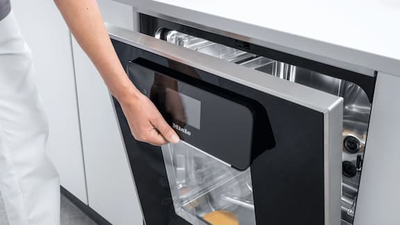 Ręka otwiera szklane drzwi termodezynfektora ExpertLine