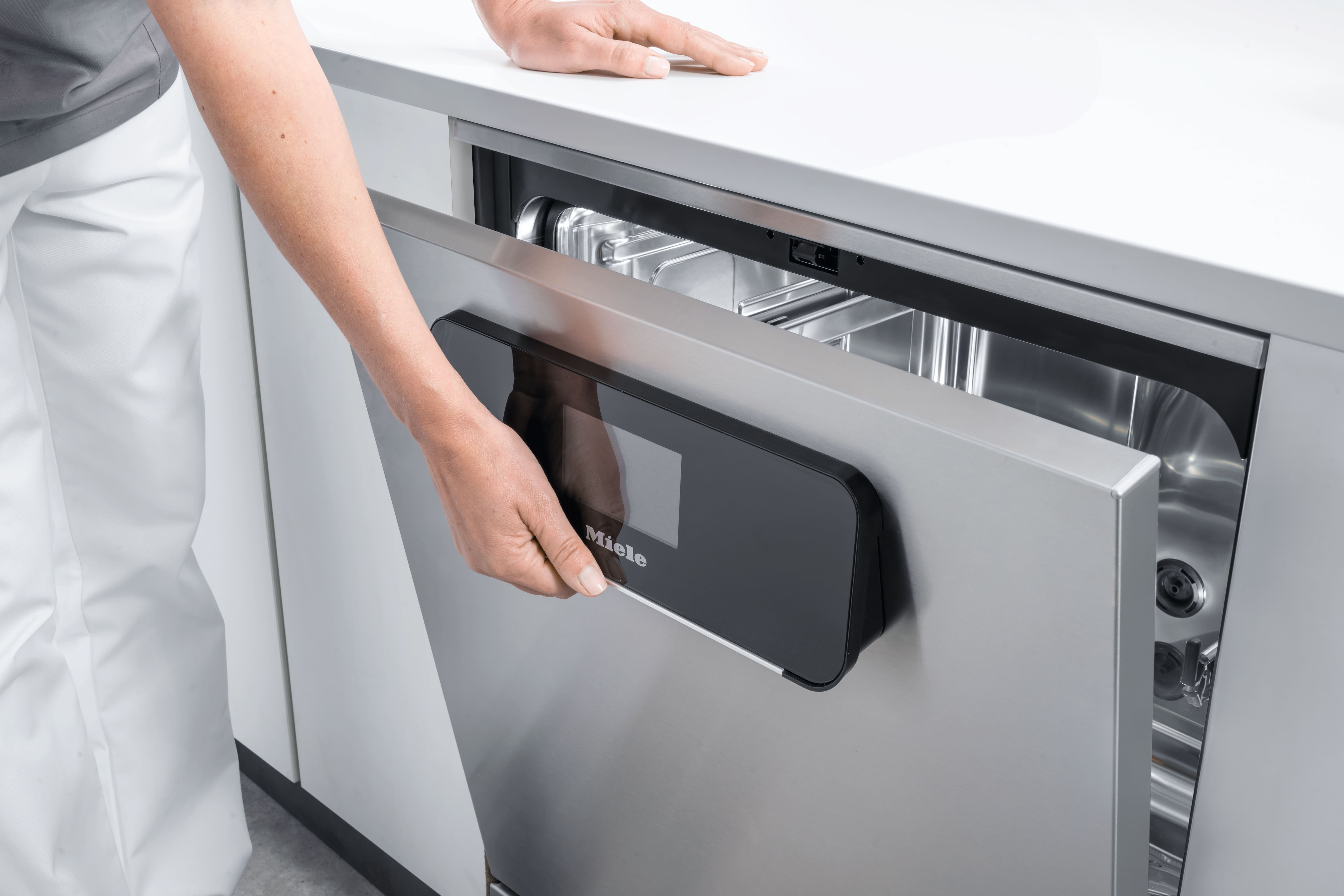 A hand with a cokctail glass in it at the railing of a ship. The sea can be seen in the background.