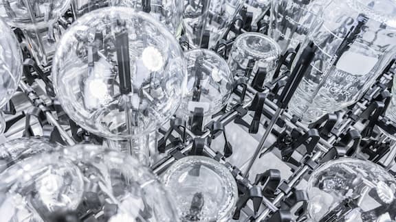 Forskellige laboratorieglas er skinnende rene og indsættes i et EasyLoad-modul med injektordyser.