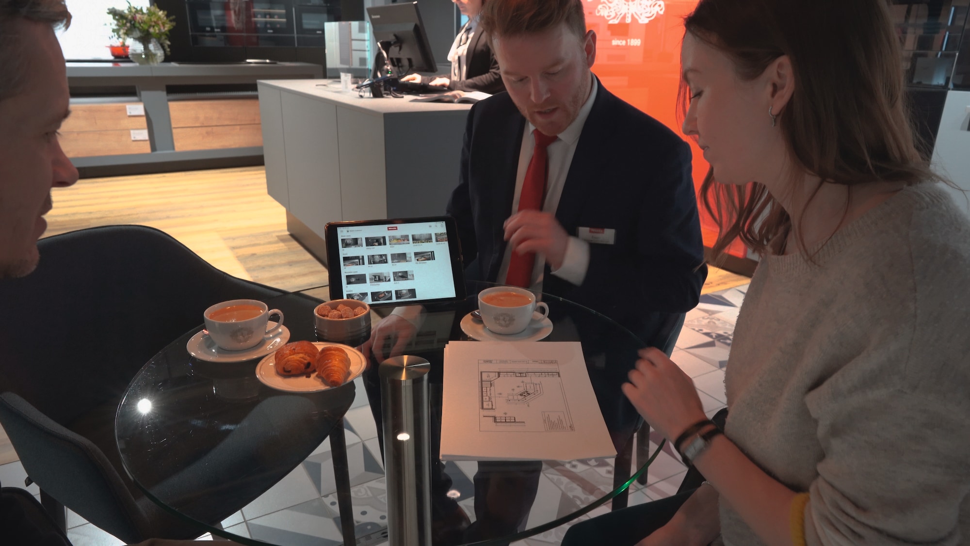Cheff with consumers having coffee from a Miele coffee machine
