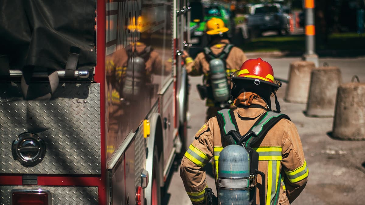 A fireman walks sideways past a fire engine