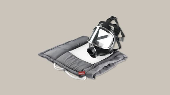 Respirator mask with reprocessing bag on a plain grey background