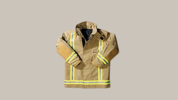 A firefighter jacket on a plain grey background