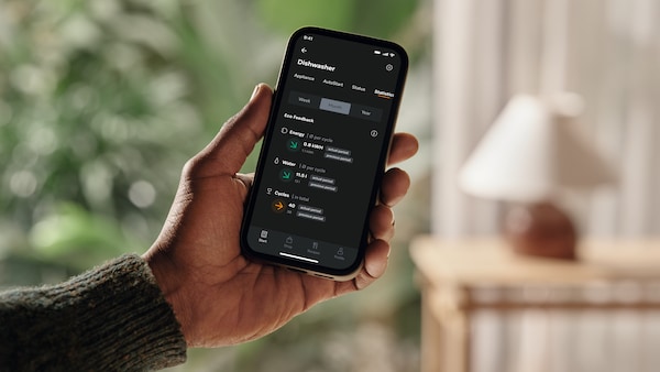 hand holding phone with Miele app open to the consumption dashboard