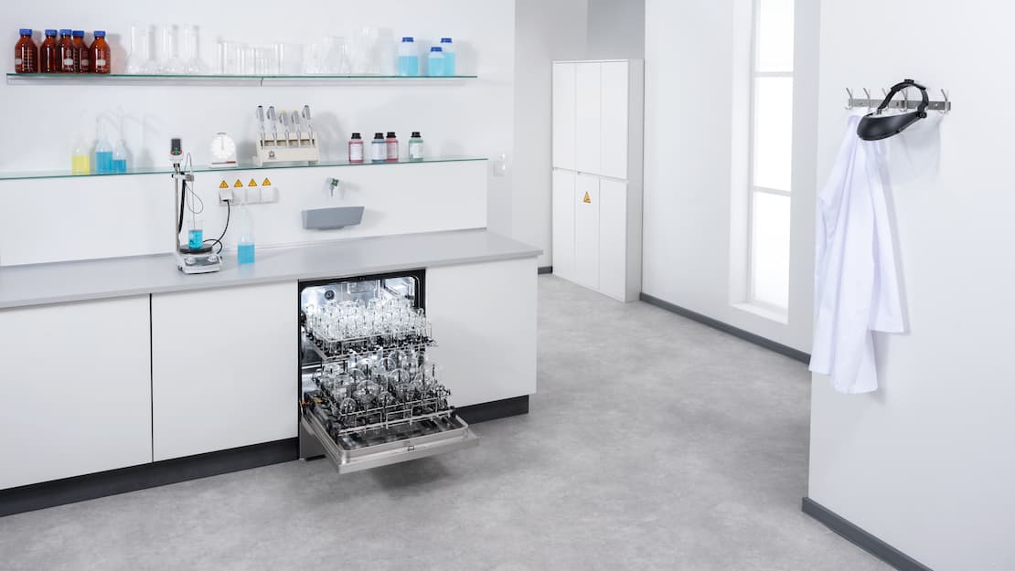 An open ExpertLine laboratory washer built into run of laboratory units and loaded with EasyLoad modules and various items of laboratory glassware.