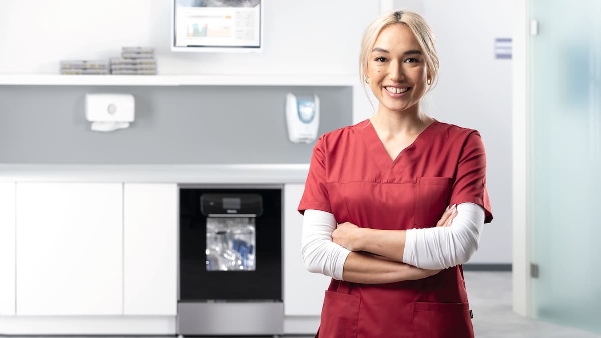 A young dentist in red hospital clothes, with the ExpertLine in the background