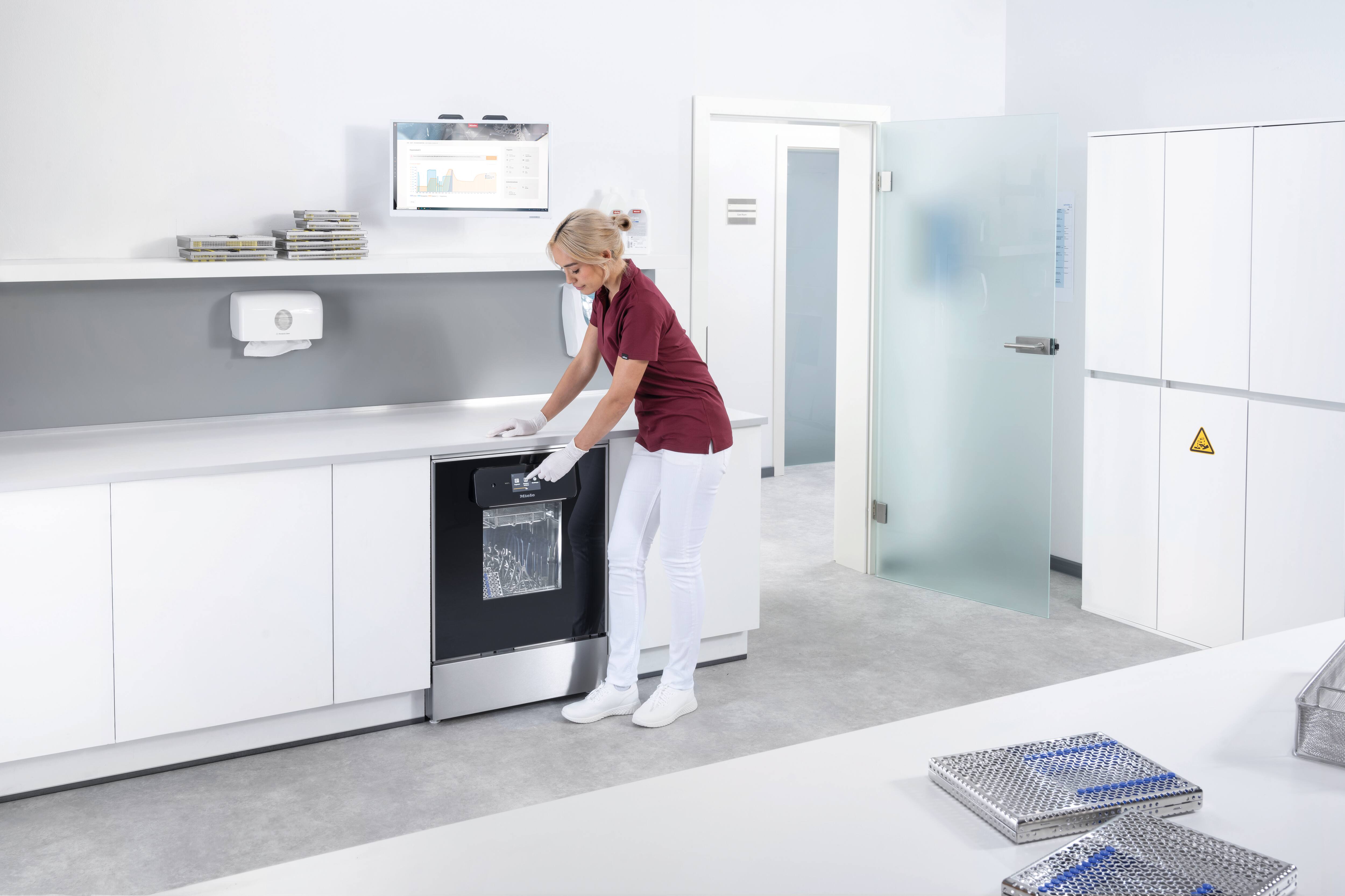 Μια βοηθός οδοντιάτρου χειρίζεται τη συσκευή ExpertLine στην αίθουσα προετοιμασίας