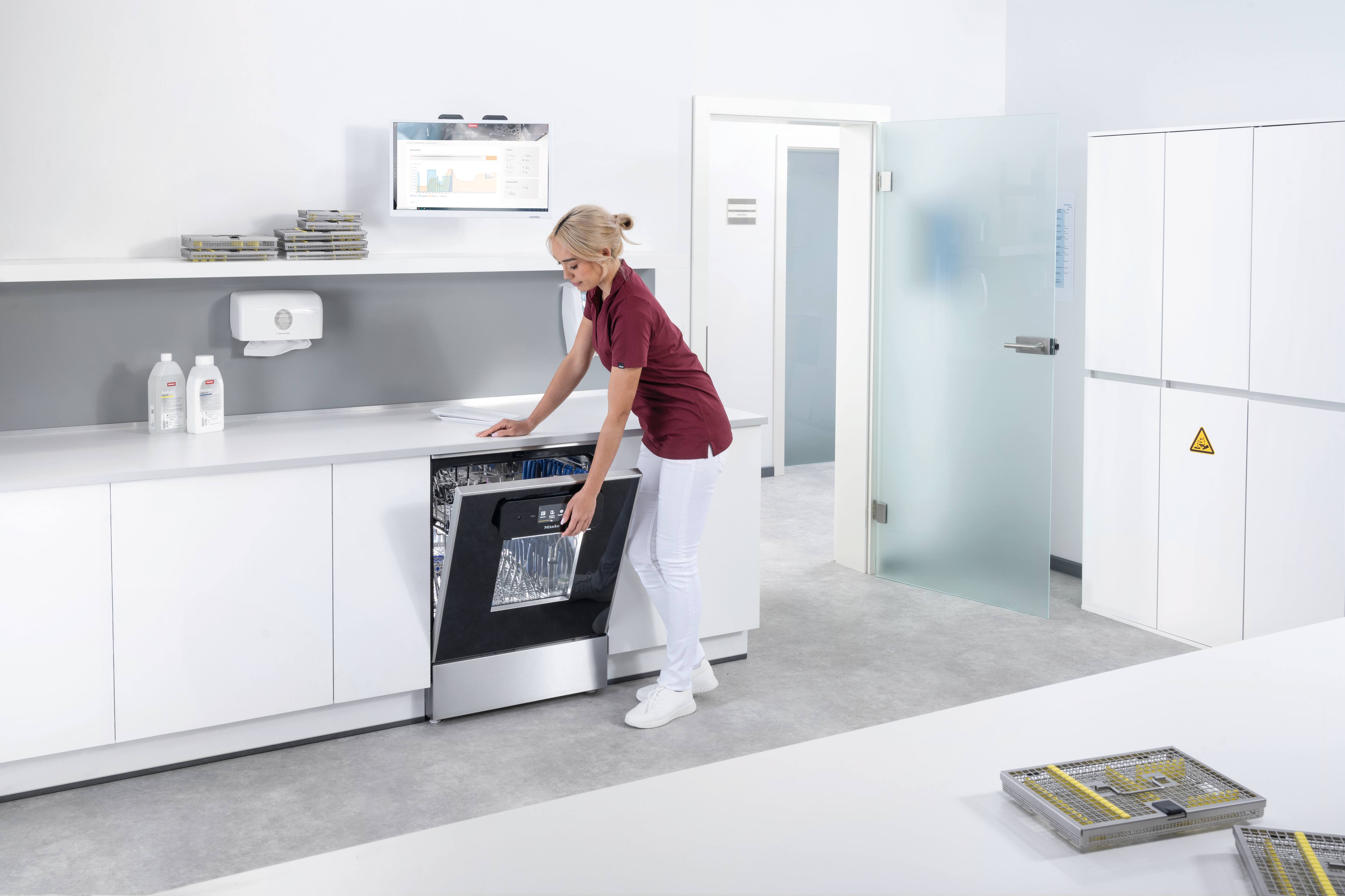 Eine medizinische Assistentin arbeitet im Aufbereitungsraum mit einem ExpertLine Thermodesinfektor