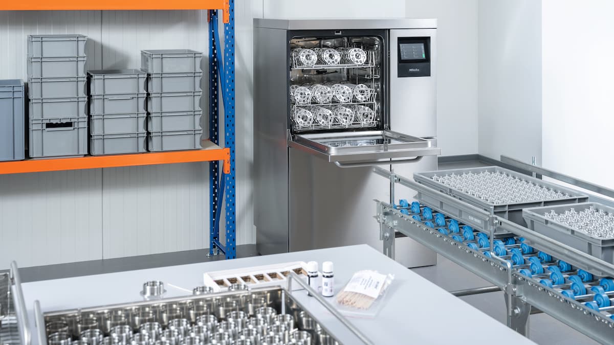 Ein geöffnetes Reinigungsgerät für die industrielle Teilereinigung PLW 8636 bestückt mit Dreh- und Frästeilen.