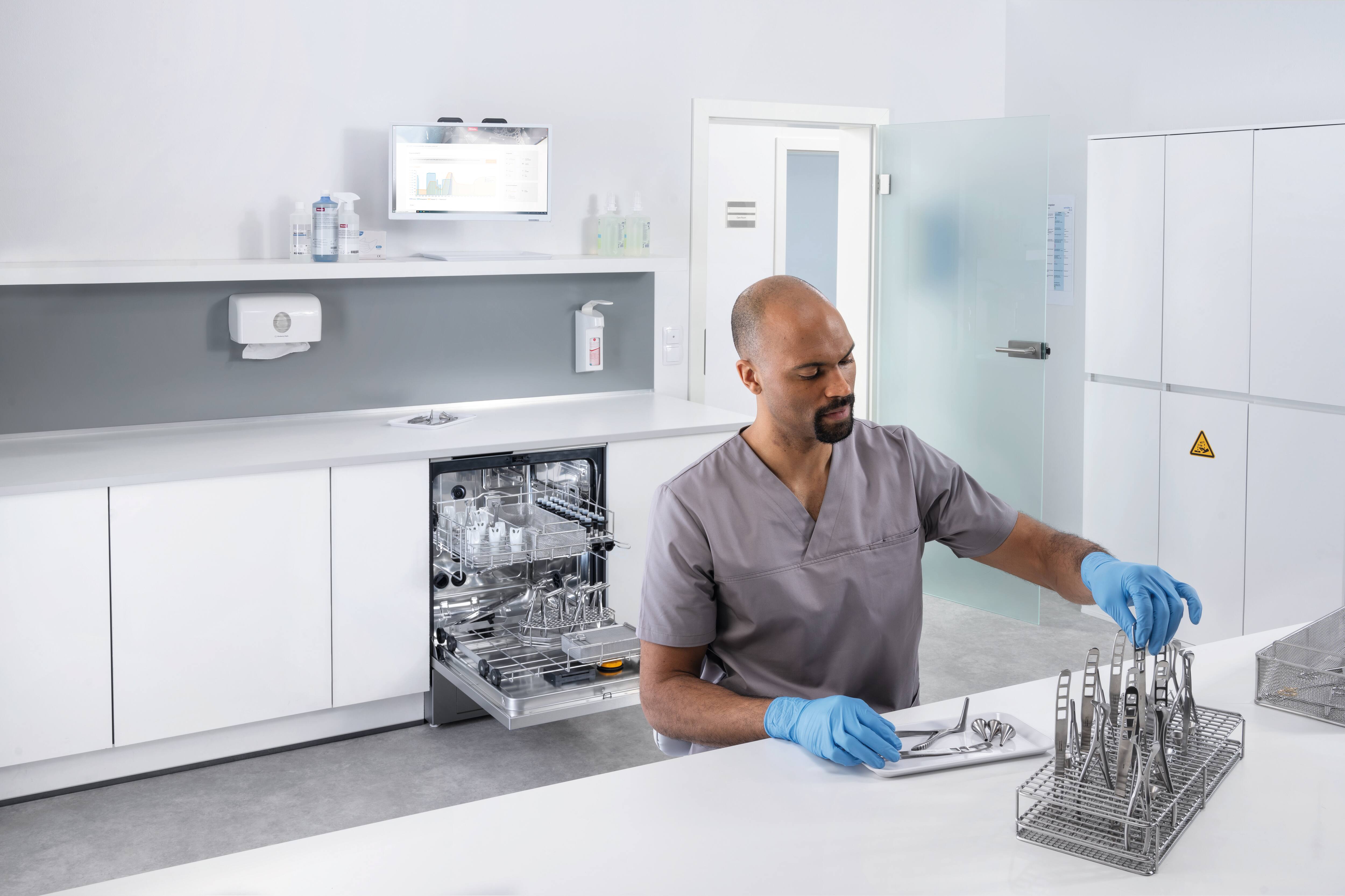 Eine medizinischer Assistent arbeitet im Aufbereitungsraum mit einem ExpertLine Reinigungs- und Desinfektionsgerät.