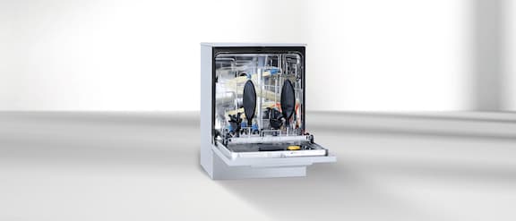 Miele PG 8582 is standing opened in front of a grey background. Inside the machine anaesthesia material from the fire brigade is placed for reprocessing.
