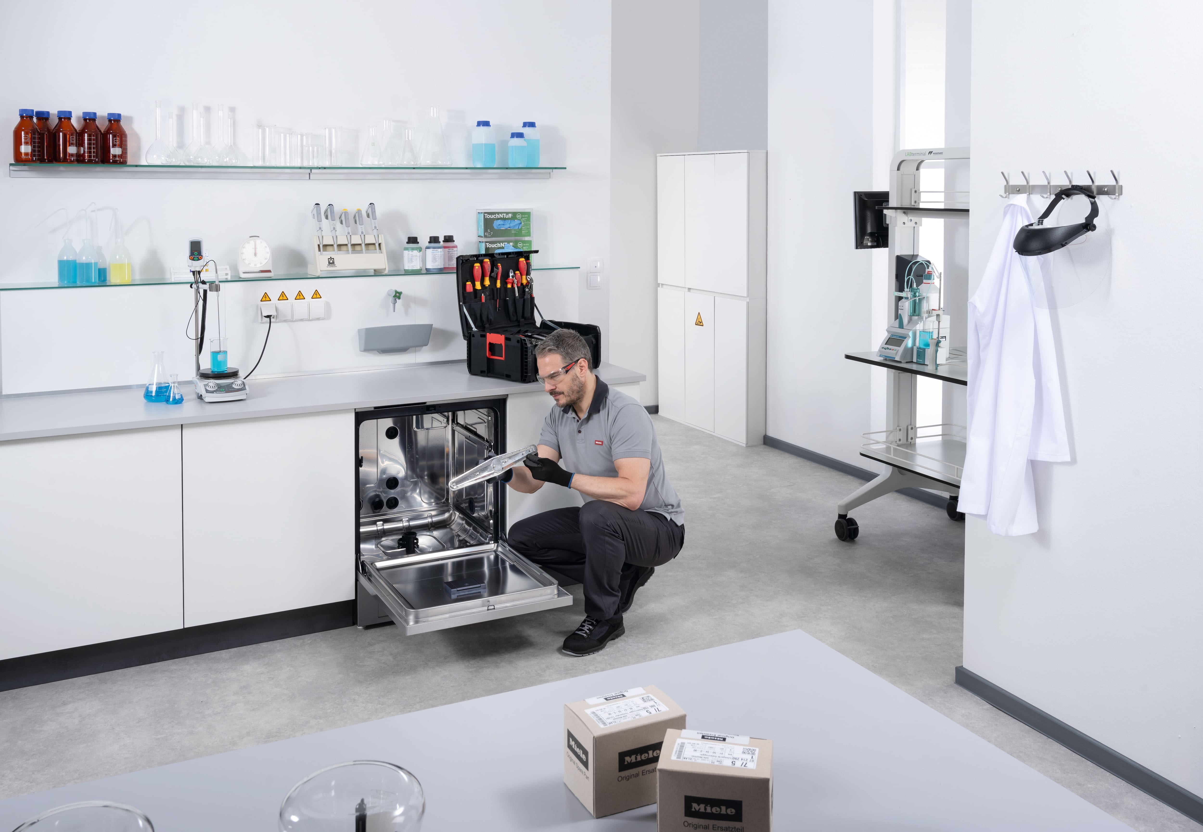 Ein Kundendiensttechniker prüft den Sprüharm eines geöffneten ExpertLine Laborspülers.